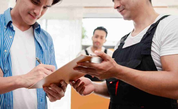 professional movers reviewing safety tips with client on moving day